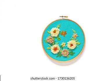 Hand Embroidery Of Floral Ornament With Woolen Threads On Green Canvas. The Flowers Are Embroidered With Punched Tapestry Or Carpet Seam, Leaves Are With Tambour Or Chain Stitch. Flat Lay, Copy Space