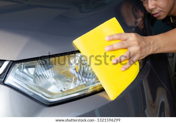 Hand of employees worker\
use clean yellow cloth to wipe the car after washing in the car\
wash shop.
