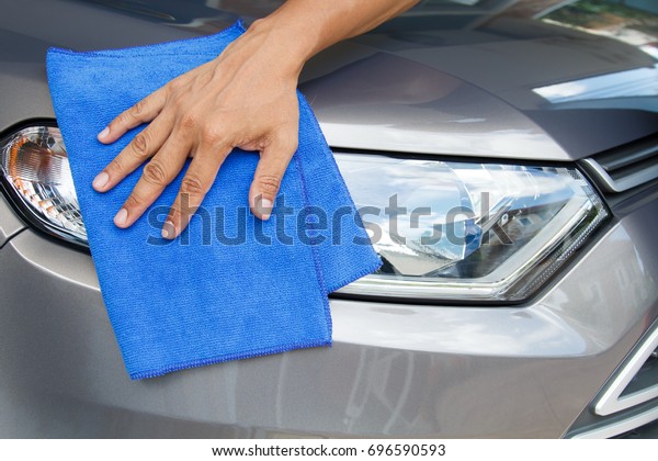 Hand of employees worker use\
clean blue cloth to wipe the car after washing in the car wash\
shop