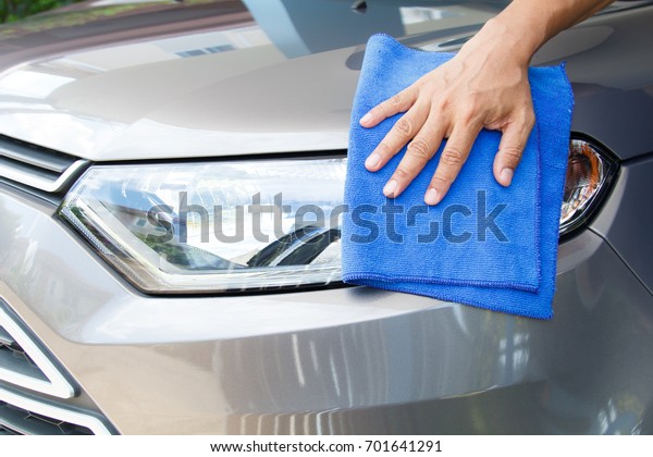 Hand of employees worker use
clean blue cloth to wipe the car after washing in the car wash
shop