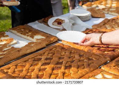 Hand With Empty Paper Plate Reaches For Portion Of Open Sweet Pie