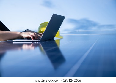 Hand of engineer using notebook on rooftop photovoltaic power station for analyze electric data, Green energy and world sustainable concept.