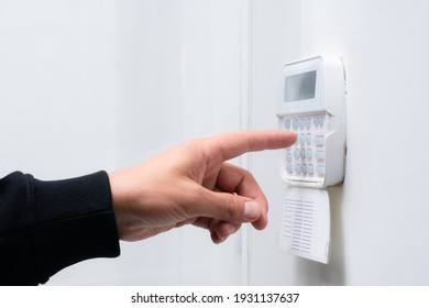 Hand entering alarm system password of an apartment, home or business office. Surveillance and protection console against rubbery and thief