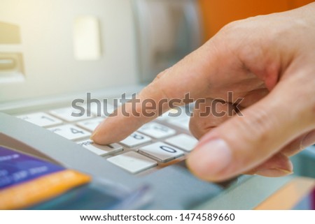 Hand entering on pin pad of ATM pass code business finance