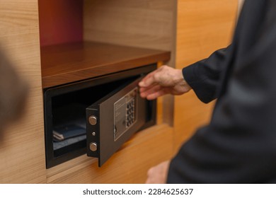 A hand enters a code to open and lock a safe or safe in hotel room Theft or keeping valuables