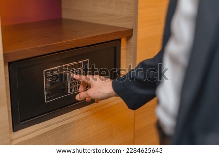 A hand enters a code to open and lock a safe or safe in hotel room Theft or keeping valuables