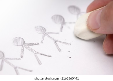 A hand with an eraser erases the painted men - Shutterstock ID 2163560441