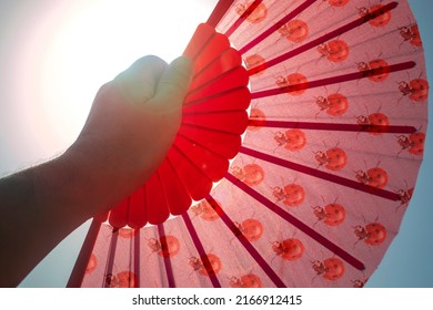 Hand fan Red.Heat wave shoots thermometers with extreme temperatures. Hand fan covering the sun to cool down and give yourself air in heat alerts. Heat wave  heatstroke concept. 