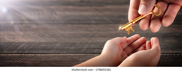 Hand Of Father Giving Old Golden Key To Child - Inheritance Concept - Shutterstock ID 1748455181