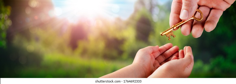 Hand Of Father Giving Old Golden Key To Child In Garden - Death And Inheritance Concept - Shutterstock ID 1764692333