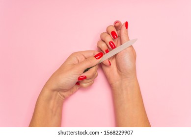 Hand Filing Nails With Glass Nail File On The Pink Background