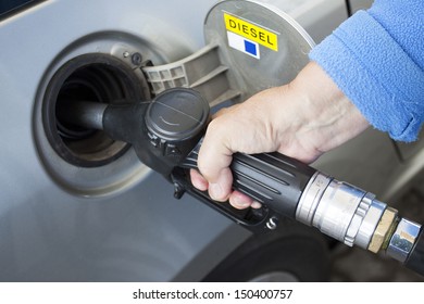 A Hand Filling Up A Car With Diesel