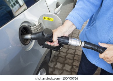 A Hand Filling Up A Car With Diesel