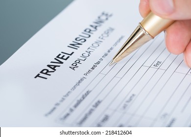 Hand Filling Travel Insurance Form. Closeup Shot