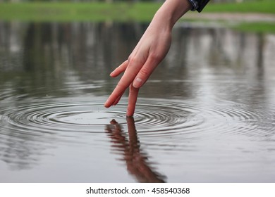 Hand Finger Touches The Water