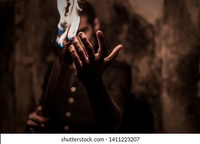 Hand with fire of a magician with vintage clothes