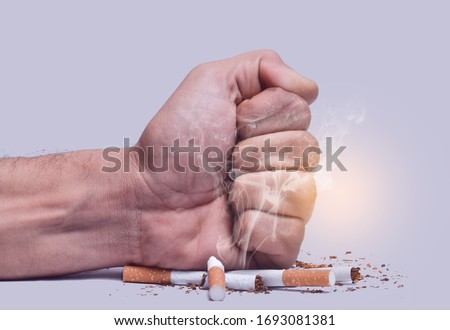 Hand fist smash or punch on cigarette.Cigarettes is addictive to be cancer.smoking reduction campaign in World No Tobacco Day.