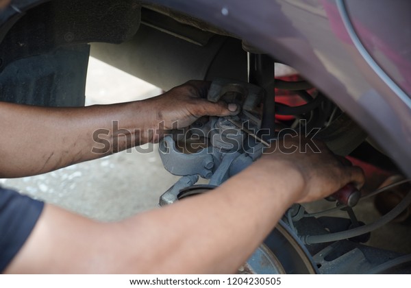 Hand fixing car\'s disc\
brake