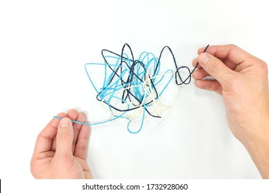 Hand fixing tangled yarn. Psychotherapy, problem solving ang critical thinking concept. - Shutterstock ID 1732928060