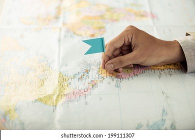 Hand With A Flag Pin On The Map Showing Destination Point