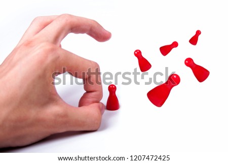 Hand flicking away small red game pieces