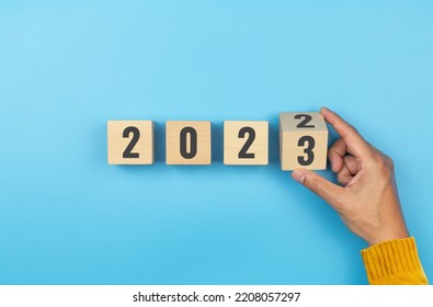 Hand flip wooden cube with the number 2022 to number 2023 on blue background. Concept of business success growth increase up - Shutterstock ID 2208057297