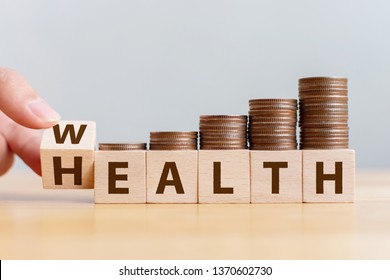 Hand flip wooden cube with word wealth to health with coins stack step up growing growth value. Investment in life insurance and healthcare concept