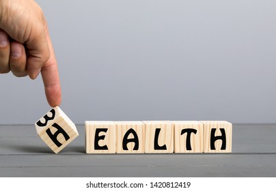 Hand flip wooden cube with word wealth to health - Shutterstock ID 1420812419