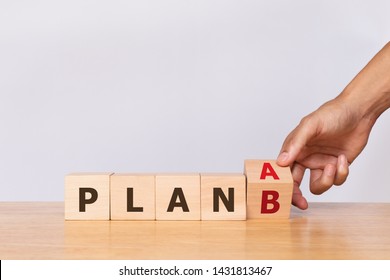 Hand Flip Wooden Cube With The Word PLAN A To PLAN B On White Background. Business Concept