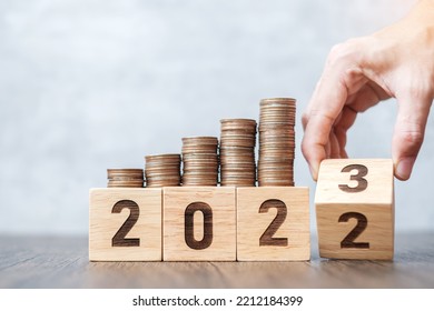 Hand flipping 2022 to 2023 year block with Coins stack. Money, Budget, tax, investment, financial, savings and New Year Resolution concepts - Shutterstock ID 2212184399