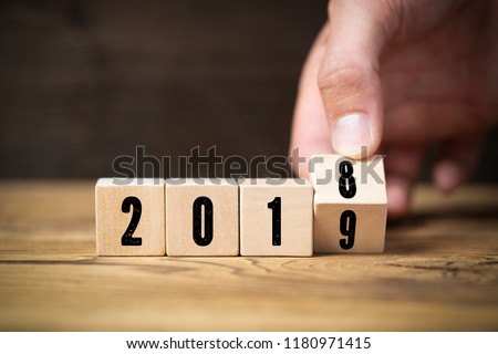 hand flipping a cube,  symbolizng the change from 2018 to 2019