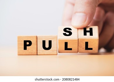Hand flipping wooden cube block to change push and pull for business strategy and customer marketing concept. - Shutterstock ID 2080821484