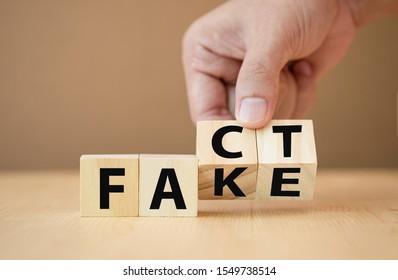 Hand flipping wooden cubes for change wording from "fake" to "fact". - Shutterstock ID 1549738514