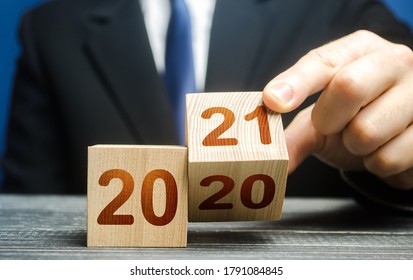 Hand flips a block changing 2020 to 2021. New year beginning. Holidays and Christmas. Trends and changes in the World. Summing work done. Keep up with everything planned. Build plans. New normal.