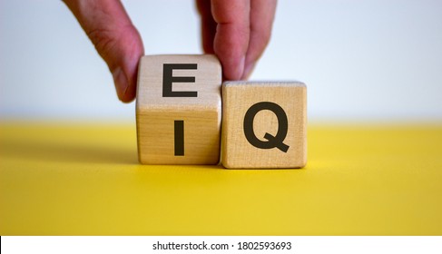 Hand flips a cube and changes the expression 'IQ' to 'EQ'. Beautiful yellow table, white background. Concept of emotional and  intelligence quotient. Copy space. - Shutterstock ID 1802593693
