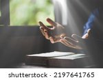 Hand folded in prayer to god on Holy Bible book in church concept for faith, spirituality and religion, woman person praying on holy bible in morning. christian catholic woman hand with Bible worship.