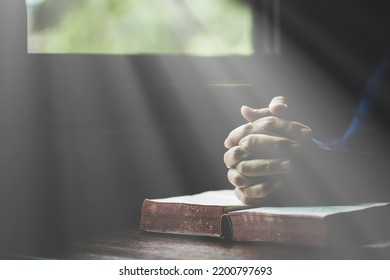 Hand folded in prayer to god on Holy Bible book in church concept for faith, spirituality and religion, woman person praying on holy bible in morning. christian catholic woman hand with Bible worship.