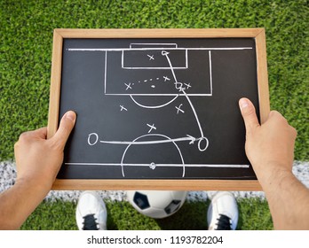 hand of a football coach drawing a tactics of soccer game with white chalk on blackboard at stadium background - Powered by Shutterstock