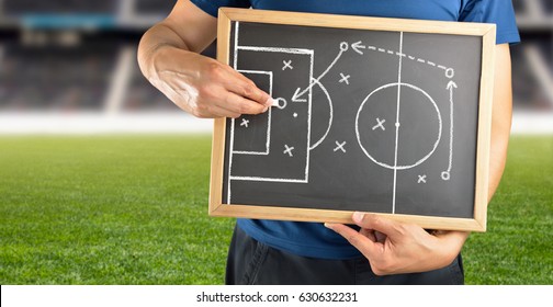 hand football coach drawing tactics soccer game and white chalk blackboard at stadium background