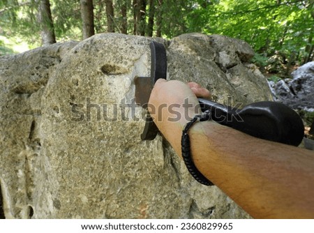 hand forcefully extracts the sword stuck in the rock as in the mythological tale of King Arthur