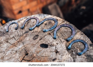 Hand forged horseshoes on a tree stump - the craft of an old fashioned blacksmith - Powered by Shutterstock