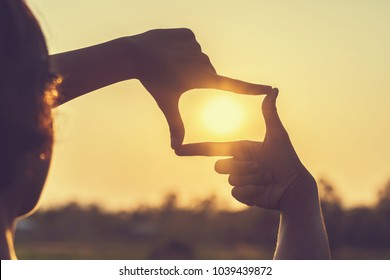 hand framing view distant over sunset - Shutterstock ID 1039439872
