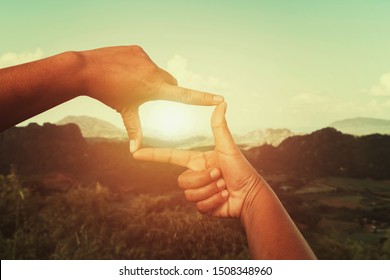 hand framing view distant over sunset. business concept