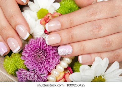 Hand With French Manicured Nails And A Bouquet Of Flowers