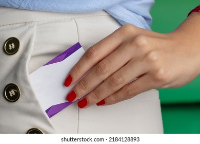 Hand gesture, female hand pulling white card from pocket. 
