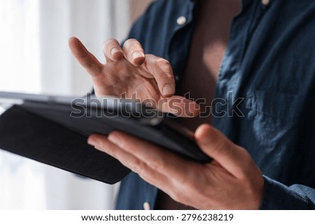 Hand gesture interacting with a tablet screen in a folio case for touch control, interface testing and app tutorial background for ux designers.