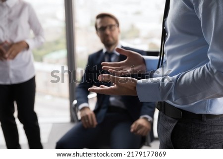 Hand gesture of male business leader talking to employees at meeting in office. Mentor, teacher giving workshop, instructions to interns. Project group brainstorming on ideas