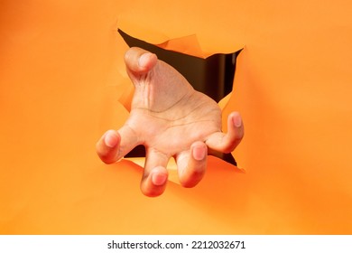 Hand Gesture On Torn Orange Paper Background