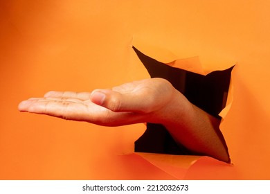 Hand Gesture On Torn Orange Paper Background