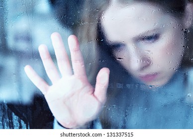 Hand Of Girl Melancholy And Sad  At The Window In The Rain